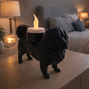 Zwarte waxinelichthouder Tibetaanse Mastiff op kastje in warme slaapkameromgeving.